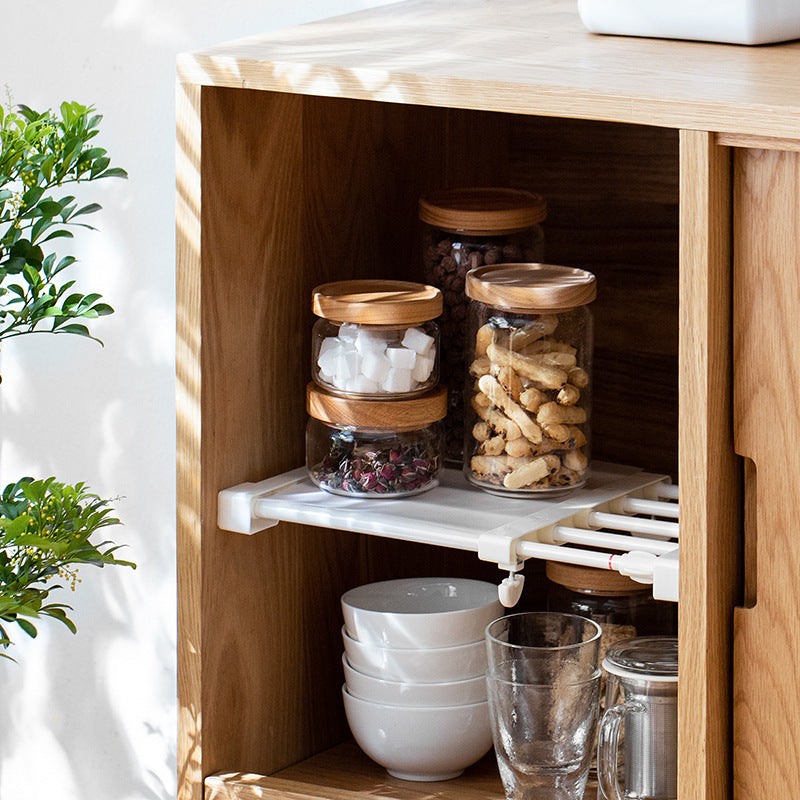 Bocal en verre avec couvercle en bois, rangement élégant pour ingrédients secs dans une étagère en bois clair.