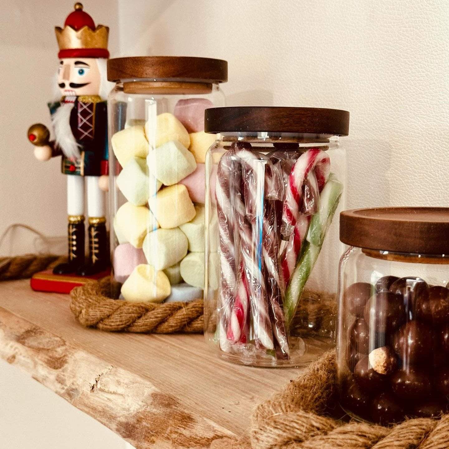 Bocal en verre transparent avec couvercle en bois pour conserver bonbons et friandises sur étagère en bois décorative
