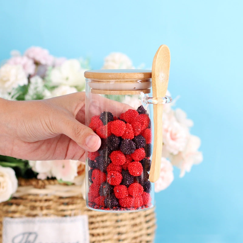 Bocaux en verre avec cuillère en bois contenant des fruits rouges, élégants et pratiques pour la cuisine.