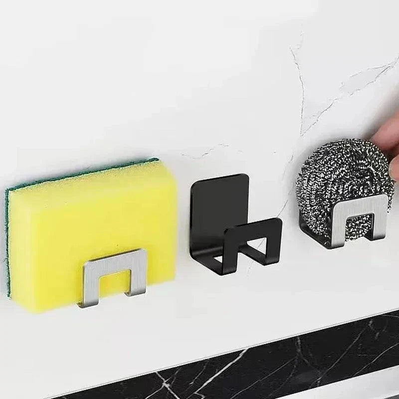 Crochets autocollants en métal inox pour rangement éponges et accessoires de cuisine, support mural noir et argenté.