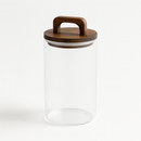 Bocal en verre transparent avec couvercle en bois à anse pour rangement d'ingrédients.