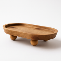 Wooden presentation tray with rounded edges and spherical legs, natural and elegant design for serving or decorating.
