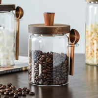 pots en verre avec couvercle et cuillère en bois pour stocker grains de café sur plan de travail de cuisine